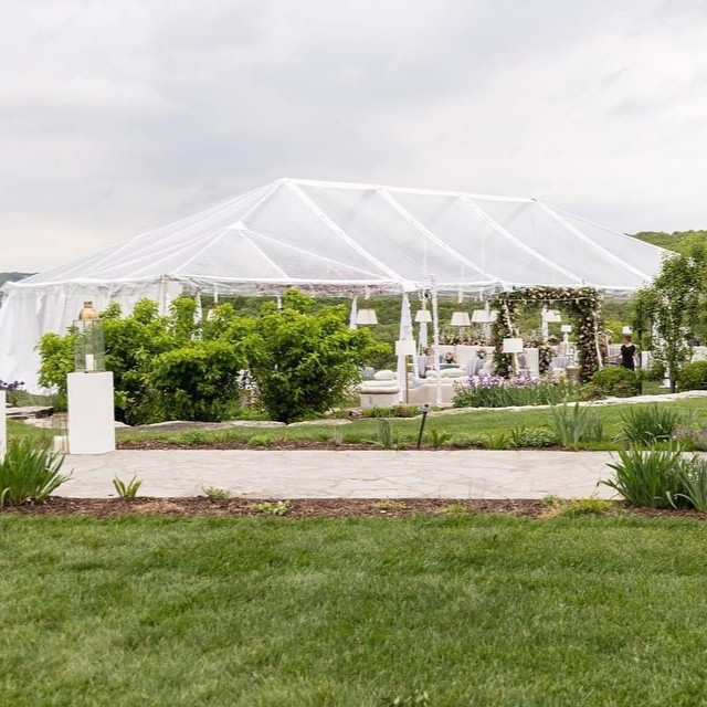 Clear-top event tent with floral arch, available through Party Central